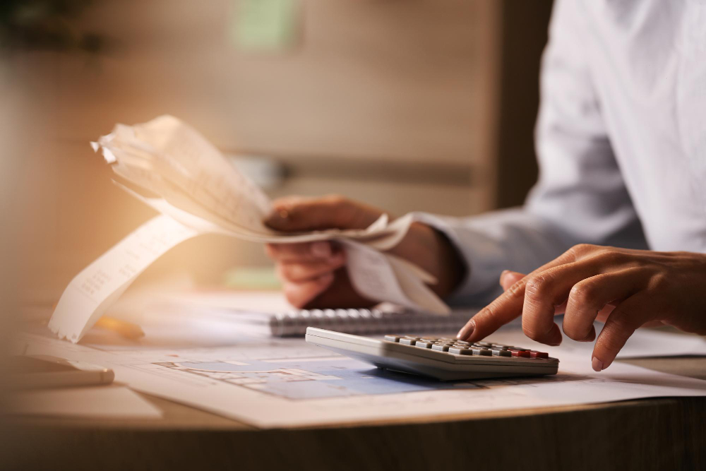 Homem com uma calculadora e notas fiscais faz contas: locação oferece benefícios fiscais mais imediatos do que a compra de aparelhos.